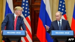 Donald Trump (stânga) îl ascultă pe Vladimir Putin la o conferință de presă în urma summitului lor de la Helsinki, din iulie 2018