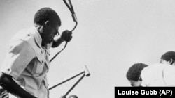 Rhodesienii bat o statuie care-l înfățișează pe fondatorul Rhodesia. Cecil Rhodes, după ce țara a devenit independentă față de puterea britanică și a luat numele Zimbabwe, 31 iulie 1980