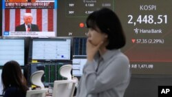 Reacția la anunțul lui Donald Trump văzută în gestul unei lucrătoare de la secția financiară a băncii KEB Hana Bank din Seoul, Coreea de Sud