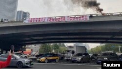 Снимка на плаката на неидентифицирания мъж върху моста Ситонг в Пекин, 13 октомври, 2022 г.