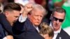 Fostul președinte american Donald Trump, candidatul republican la președinție, este escortat de agenți ai Serviciului Secret după ce asupra sa au fost trase focuri de armă în timpul unui miting de campanie în Butler, Pennsylvania, pe 13 iulie 2024.