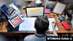 Több táblagépe segítségével készíti el egy középiskolás fiú a történelemből kapott feladatait 2020. március 17-én.