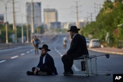 Evrei ortodocși protestând prin blocadă rutieră împotriva înrolării, aproape de Tel Aviv, la 19 august 2025.
