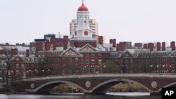 Un pod peste râul Charles, care curge prin fața Universității Harvard din Cambridge, văzută în depărtare, 15 aprilie 2025