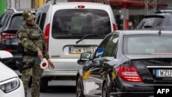 Un membru al pazei frontierei poloneze oprește o mașină la granița germano-poloneză, la 7 iulie 2025. 