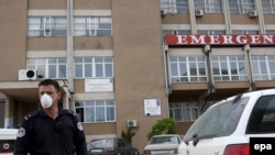 Policajac nosi zaštitnu masku ispred bolnice u Prištini