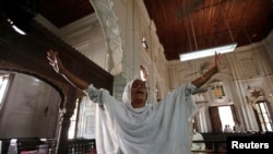 FILE: A Christian woman cries in the church where her son died in a suicide attack in the northwestern city of Peshawar in September 2013.