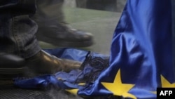 Égett EU-zászlón tapos egy tüntető a Jobbik 2012. január 14-ei budapesti tüntetésén