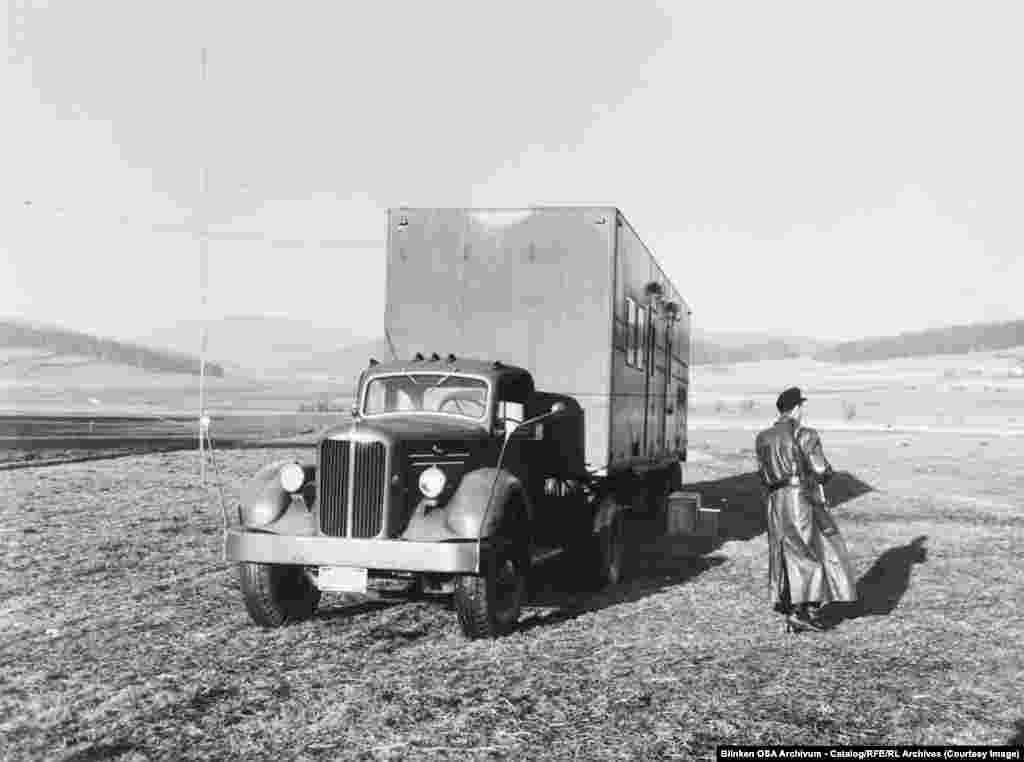 Вооруженный охранник патрулирует грузовик со средневолновым радиопередатчиком в Западной Германии, недалеко от границы с Чехословакией, в 1955 году.Поскольку коммунистические государства начали глушить передачи РСЕ и Радио Свобода, Радио Свободная Европа развернуло десятки мобильных передающих станций, таких как та, что изображена здесь, которые могли работать в непосредственной близи от «железного занавеса»