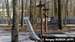 Unutarnje komponente rakete kalibra 300 mm za koje se čini da su sadržavale kasetne bombe lansirane iz višecjevnog raketnog bacača BM-30 Smerch ukopane su u zemlju pored grobova u blizini Spomen obilježja žrtvama totalitarizma u šumi na periferiji Harkiva. 23. marta 2022.