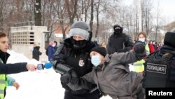 Čovek s medijskom identifikacijom drži mikrofon dok policija privodi demonstranta na skupu podrške ruskom opozicionom lideru Alekseju Navaljnom, Sankt Peterburg 31. januara.
