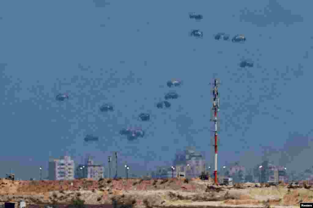 Пакеты гуманитарной помощи сбрасываются с воздуха над сектором Газа, вид из Израиля, 6 августа 2025 года. REUTERS/Amir Cohen