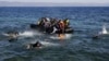 FILE: Afghan and Syrian refugees struggle to swim from a dinghy with a broken engine that drifts out of control to a rocky beach on the Greek island of Lesbos after crossing a part of the Aegean Sea from Turkey in September 2015