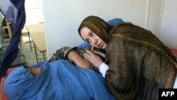 Sara Qasimi, de la Medecins du Monde, examinează o gravidă lângă Herat, în noiembrie 2001.