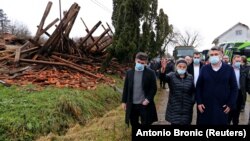 Hrvatski predsjednik Zoran Milanović (prvi zdesna) i zamjenica gradonačelnika Gline Branka Bakšić-Mitić (druga zdesna) u obilasku naselja Majske Poljane, dan nakon jakog potresa (30. prosinca)