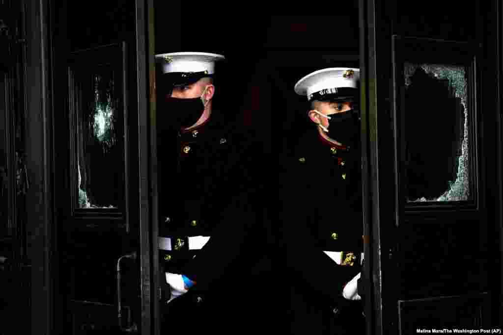 Američki marinci stoje uz oštećena vrata Capitola tokom probe za 59. ceremoniju inauguracije izabranog predsednika Joea Bidena i novoizabrane potpredsednice Kamale Harris održane u ponedeljak, 18. januara u američkom Capitolu u Washingtonu.