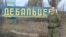 Казак Евгений Панчук у стенда названием украинского города Дебальцево, на котором можно увидеть надписи "Новосибирск", "ВДВ".