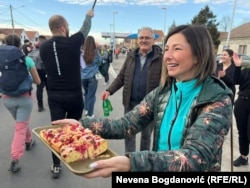 Žena daje kolače studentima koji prolaze kroz Batajnicu, 30. januar 2025.