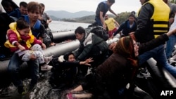 Migrants and refugees arrive on Sykamia beach, west of the port of Mytilene, on the Greek island of Lesbos after crossing the Aegean sea from Turkey on September 22.