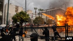 Un grup de protestatari ciocnindu-se cu forțele de ordine lângă Parlamentul din centrul Atenei, vineri, 28 februarie.