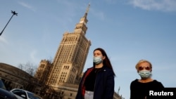 Prolaznici sa maskama na ulicama Varšave, 2021.