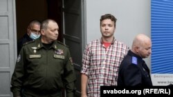 Șeful Aviației și Apărării Aeriene Igor Golub (stânga), activistul Raman Pratasevici (centru) și președintele Comitetului de Investigații din Belarus, Dmitry Gora (dreapta)