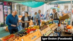 Unul din liderii Blocului Patriotic, Igor Dodon (stânga), în timpul campaniei electorale la o piață agroalimentară din Șoldănești. Printre promisiunile blocului sunt și cele de a majora exportul de fructe și legume către piețele CSI.