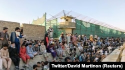 Луѓе чекаат надвор пред аеродромот во Кабул. 25 август 2021 година.