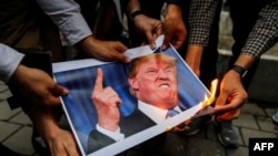 Iranci spaljuju sliku američkog predsednika Donalda Trampa tokom demonstracija ispred ambasade SAD u Teheranu posle povlačenja Vašingtona iz nuklearnog sporazuma u maju 2018.