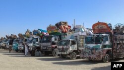 Afganistanske izbjeglice čekaju pored kamiona natovarenih njihovim stvarima prije odlaska u Afganistan u centru za zadržavanje blizu granice u Čamanu, Pakistan, 27. aprila.