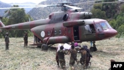 Soldați talibani duc o victimă spre elicopter în satul Mazar Dara, pe 2 septembrie.
