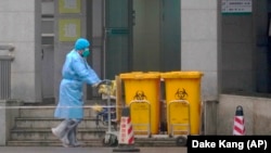 Medicinski tehničar odlaže pribor koji je vjerojatno inficiran novim korona virusom, Wuhan, 22. siječnja