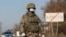 KAZAKHSTAN -- A Kazakh serviceman wearing a protective mask stands guard at a check point, following the state emergency commission's decision to lock down Almaty to prevent the spread of coronavirus disease (COVID-19), on the outskirts of Almaty, Kazakhs