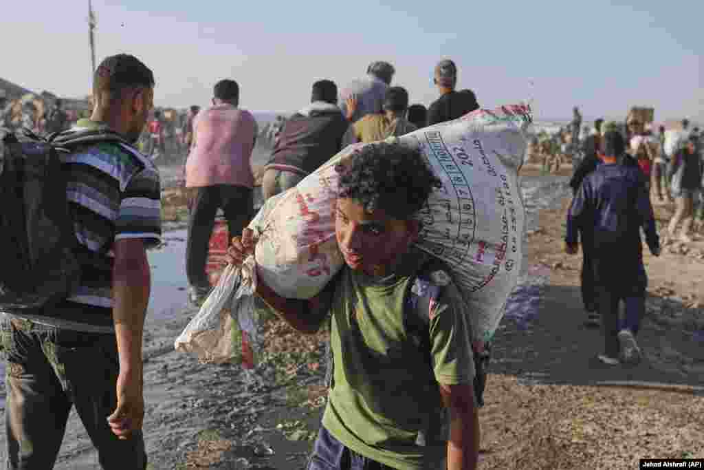 Një djalë palestinez duke bartur një thes me ndihma.