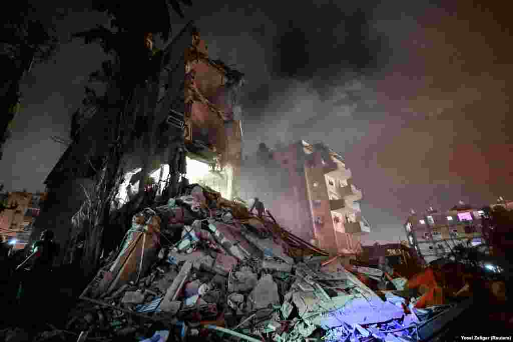 Personeli i shpëtimit duke u angazhuar në një ndërtesë banimi, pas një sulmi raketor nga Irani, në Izraelin qendror, më 15 qershor.