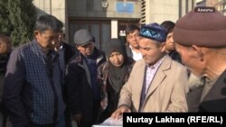 Кыдырали Оразулы (второй справа) вместе с переехавшими из Китая казахами, которые пришли к представительству МИД Казахстана в Алматы, чтобы выразить обеспокоенность положением взятых под стражу в Синьцзяне родственников. 25 октября 2017 года.