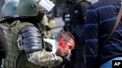 Interventna policija privodi demonstranta tokom skupa opozicije u Minsku protiv izbornih rezultata, 13. septembar 2020.