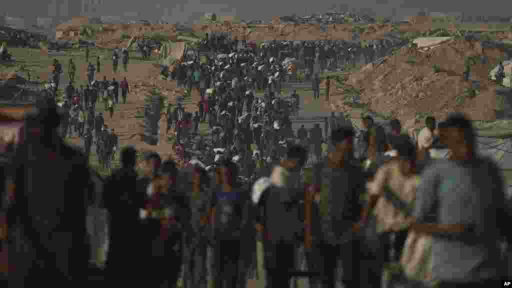 Palesztinok liszteszsákokkal. Az adomány egy segélyszervezettől jött. A gázai egészségügyi minisztérium szerint Izrael Hamász elleni katonai offenzívájának kezdete óta 62.000 palesztin, főként civil vesztette életét, a terület nagy része romokban, és szinte az egész lakosság belső menekültté vált