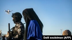 Žena iz Srednje Azije povezana sa IDIL-om u pratnji snaga koje podržavaju SAD, sjeveroistočna Sirija, grad Kamišli, maj, 2019.