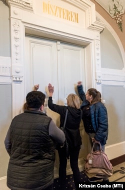 Ellenzéki szimpatizánsok a Győri Közgyűlés alakuló ülése közben a városháza dísztermének ajtaján dörömbölnek 2019. november 7-én. Az alakuló ülés ideje alatt a terem ajtajait teremőrök tartották zárva.