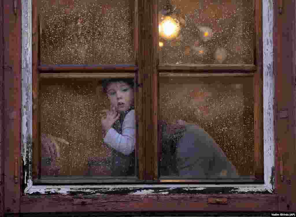 Un copil privește pe fereastră pregătirile pentru Summitul informal al liderilor UE de la Sibiu.