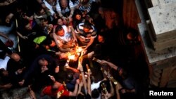 Ortodox keresztény hívők a szent tűz szertartáson a Szent Sír-templomban Jeruzsálem óvárosában 2019. április 27-én