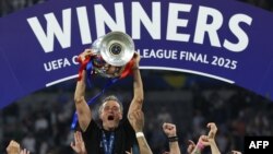 Старши треньорът на "Пари Сен Жермен" Луис Енрике ликува с трофея от Шампионската лига, вдигнат от своите играчи след разгромната им победа с 5:0 на финала срещу "Интер" в Мюнхен, 31 май 2025 г.