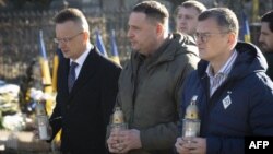 Hungarian Foreign Minister Peter Szijjarto (left), Andriy Yermak (center), the head of Ukraine’s presidential office, and Ukrainian Foreign Minister Dmytro Kuleba pay tribute at a monument for Ukrainian soldiers in Uzhhorod on January 29.