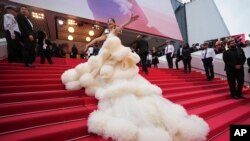 Cunoscut publicului larg pentru vedetele defilând pe covor roșu și petrecând pe iahturi, festivalul de film de la Cannes este și un mare târg (în imagine, actrița chineză Wan QianHui, pozând la ceremonia de deschidere a celei de-a 78-a ediții a festivalului, pe 13 mai 2025)