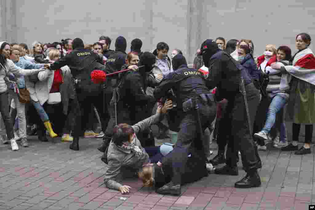 Ofițerii de poliție arestează câteva protestatare.&nbsp;