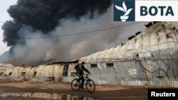 Një person kalon me biçikletë pranë një vendi të sulmuar me dronë nga Rusia në Ukrainë më 11 mars 2025. 