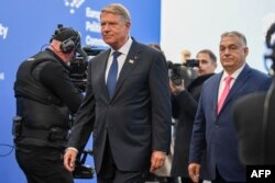 Președintele român Iohannis (stânga) se află la unul din ultimele lui summituri ca șef de stat.