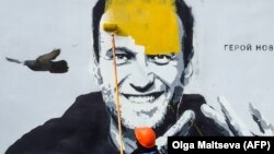 Работник префарбува графит на затворениот критичар на Кремљ Алексеј Навални во Санкт Петербург, 28 април 2021 година1