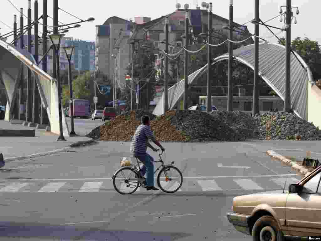 Biciklista prolazi pored barikada na mostu koji deli Mitrovicu na većinski srpski i većinski albanski deo, 15. septembar 2011, Foto: REUTERS/Marko Đurica